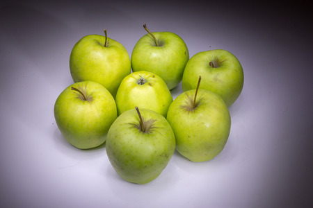 Lucky seven green apples painted with lightの写真素材