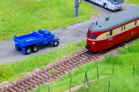 Blue scale truck on model train railroad layout road near trainの写真素材