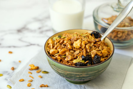Healthy breakfast with bowl of granola cereal with oats, walnut, pumpkin seeds and dried...