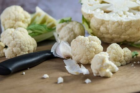 Close up of cauliflower florets on chopboard, preparing for mealの写真素材