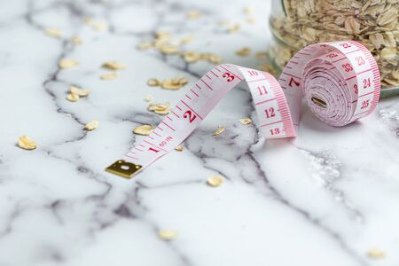 Measuring tape and rolled oats for healthy slimming diet concept, with copy spaceの写真素材