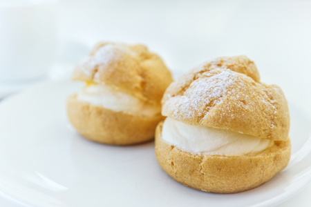 Cream puff and coffee on white backgroundの写真素材