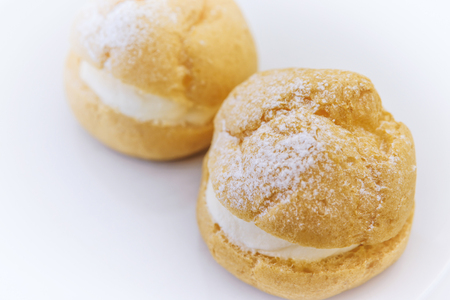 Cream puff and coffee on white backgroundの写真素材