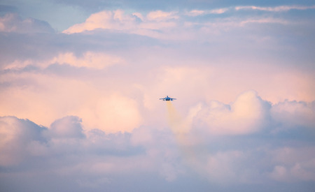 The fighter plane which flies in the evening skyの写真素材