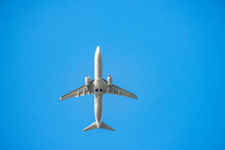 The passenger plane which flies in the blue skyの写真素材