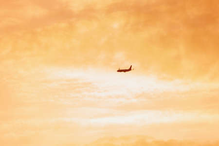 The passenger plane which takes off for the sunset skyの写真素材