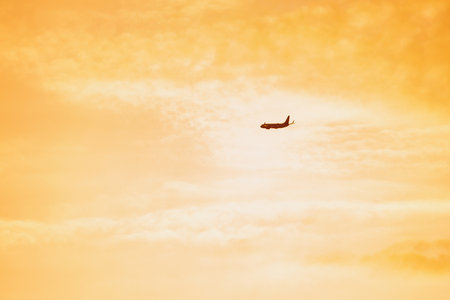 The passenger plane which takes off for the sunset skyの写真素材