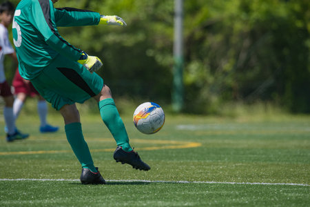 Soccer player in action with ball on the field during soccer gameの写真素材
