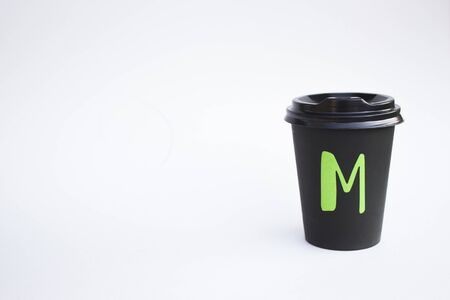 Disposable black cardboard cup isolated on a white background, Eco cup for coffee and tea. Ecology Idea Concept.の写真素材