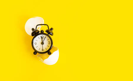 Black clock on a yellow backgroundの写真素材