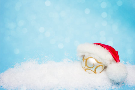 Christmas card, with a ball for the Christmas tree in Santa Claus hatの写真素材