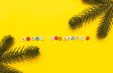 Christmas composition minimalism, letters merry christmas on yellow background