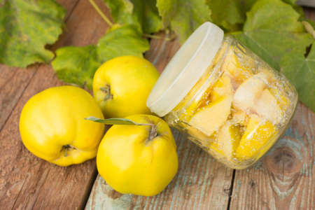 Quince, glass jar with candied quince on wooden background.の写真素材