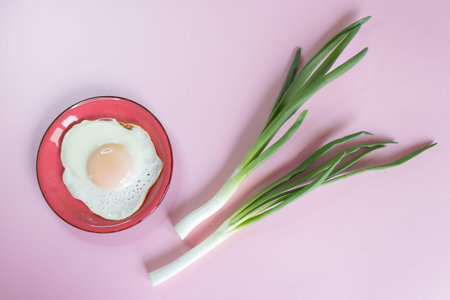 fried eggs and young green onions on the background
