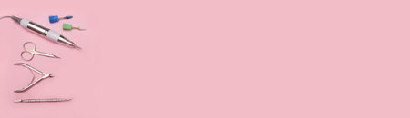 Banner nail care. Cutters for hardware manicure. Accessories and nail tool on pink background. Milling cutter for manicureの写真素材