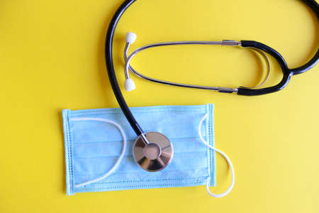 Top view black stethoscope on yellow background. For check heart or health check up conceptの写真素材