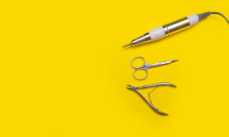 Nail tool. Cutters for hardware manicure. Accessories and nail tool on yellow background.の写真素材