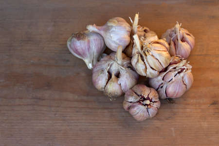 Ripe garlic, dried garlic on a wooden table. Autumn harvest of garlic. Flat lay, copy spaceの写真素材