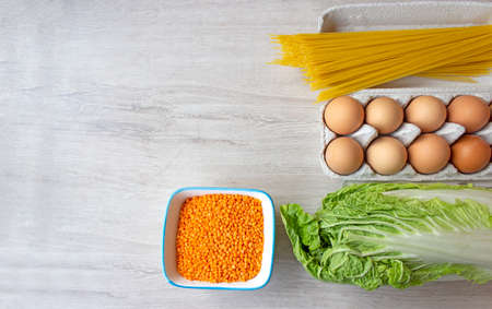Vegetable set of spaghetti products, cabbage, a tray of chicken eggs and lentils. Copy space. Food donationの写真素材