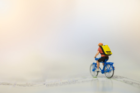 Travel and Sport Concept. Miniature figure of man ride bicycle on mapの写真素材