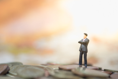 Money, Financial, Business Growth concept, Businessman miniature figures stand and thinking to business plan on top of pile of coinsの写真素材