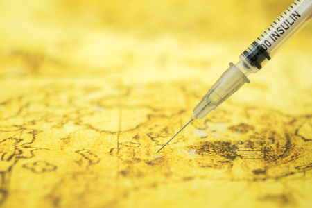Close up of syringe inject insulin to world map. Using as Medicine, Blood sugar level, diabetes, glycemia, health care and people conceptの写真素材