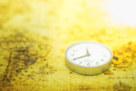 Travel and time concept. Close up of round  watch on world map.の写真素材