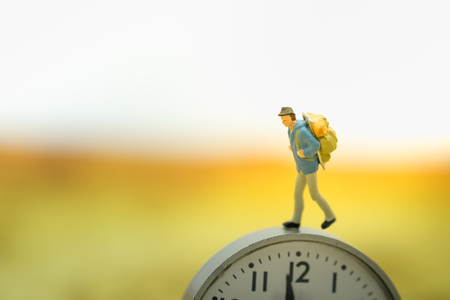 Travel and time concept. Traveler miniature people figure walking on watch.の写真素材