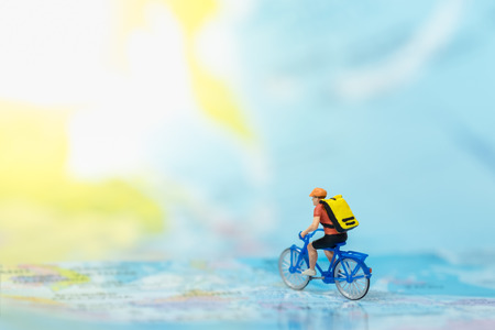 Travel and Sport Concept. Miniature figure of man ride bicycle on mapの写真素材