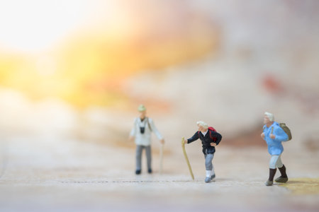 Travelling concepts. Group of traveler hiking  miniature mini figures with backpack  walking on map