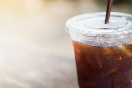 Close up of plastic take away glass of iced black coffee (Americano)の写真素材
