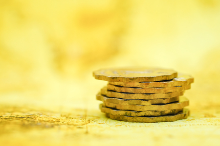 Money, business and Risk concept. Close up of instable stack of silver coins on world map.の写真素材