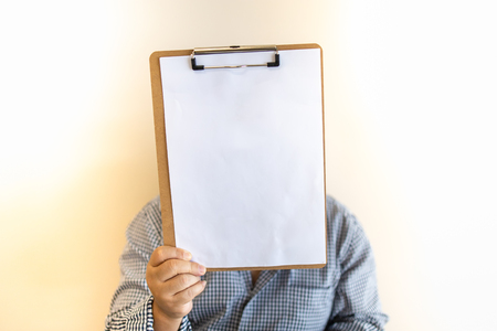 Close up of fat man holding clipboard with blank white paper copy space for text.の写真素材
