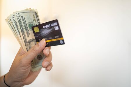 Money and Business concept. Close up of man hand holding credit card and 20 US dollars banknote with copy space.の写真素材