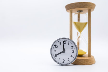 Time Management Concept. Vintage round clock with sandglass on white background and copy space for...