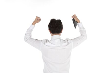 Portrait of back of smart young asian businessman holding computer tablet and Lift up the fist to celebrate on isolated white background. Image for business, technology and work concept.の写真素材