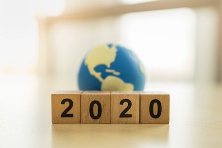2020 New year , Global and Business concept. Close up of stack of wooden number block and mini world toy ball with copy spaceの写真素材