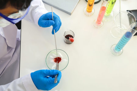 Asian professional doctor scientist wearing glasses and blue rubber gloves using needle and forceps...
