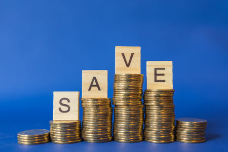Business, Money and Saving Concept. Closeup of Englisg letter  save wooden block on top of stack of...