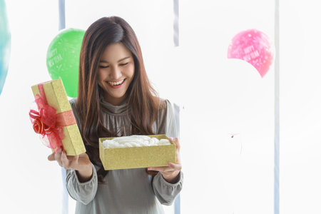 Happy New Year, Christmas and Holiday Seasonal Concept. Portrait of young asian woman holding and...