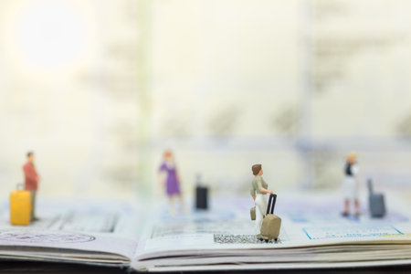 Travel Concept. Group of traveler miniature figure people with baggage on passport with immigration...