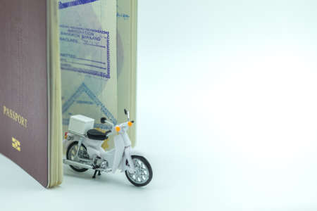 Transport and Travel concept. Closeup of motorcycle miniature toy with passport with immigration stamped.の写真素材