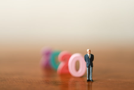 2020 Business Concept. Closeup of businessman miniature figure people standing with colorful wood...