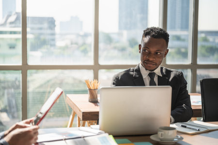 Diversity Business and Work place concept. Young African businessman with laptop computer and notebook woking in officeの写真素材
