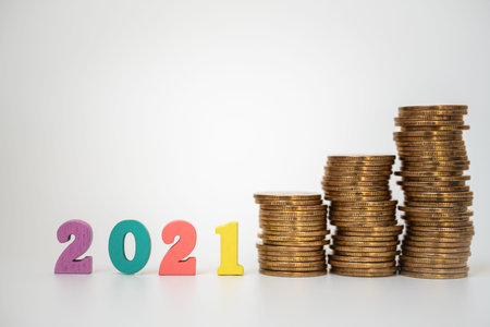 2021 Money, Business and planning Concept. Colorful wooden number letter with unstable stack of gold...