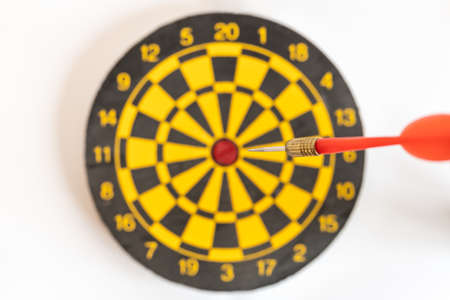 Business and Target Concept. Closeup of red darts dash to center of yellow and blck dartboard.の写真素材
