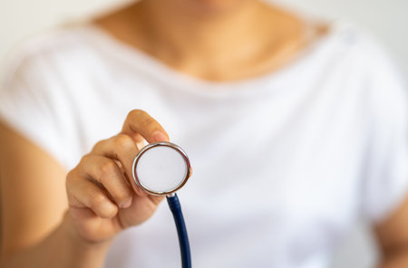 People and Healthcare concept. Closeup of woman hand holding doctor stethoscope.の写真素材