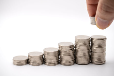 Business , Financial and Saving Concept. Closeup of stack of silver coins with man finger holding...