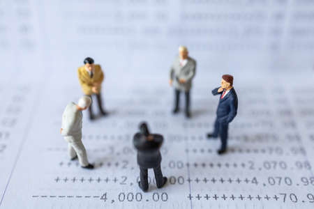 Business Financial and Teamwork Concept. Group of businessman miniature figures people standing on bank passbook.の写真素材