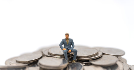Business, Money Investment and Planning Concept. Businessman miniature figure people figure sitting on pile and stack of silver coins on white background.の写真素材
